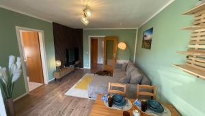 a living room with a couch and a tv at Charming accommodation in Radebeul Altkötzenbroda in Radebeul