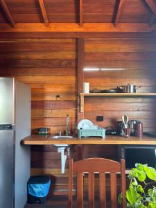 Canto do Mar - Atins - Lençóis Maranhenses في أتينز: مطبخ بجدران خشبية وطاولة مع حوض