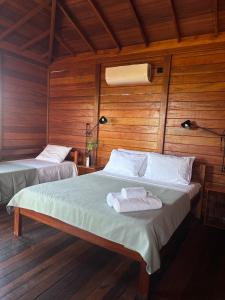 um quarto com 2 camas e paredes de madeira em Canto do Mar - Atins - Lençóis Maranhenses em Atins mais 17 fotografias