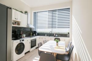 a kitchen with a white table and chairs and a window at Mi Casa Chios in Chios