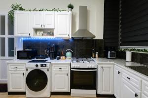 a kitchen with white cabinets and a stove top oven at Mi Casa Chios in Chios +15 photos