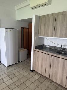 una cucina con un frigorifero bianco e un lavello di Bugan Paiva flatpaivahome a Recife