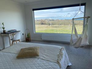 a bedroom with a bed and a large window at Casa Cálida entorno natural con vista al Estrecho in Leñadura
