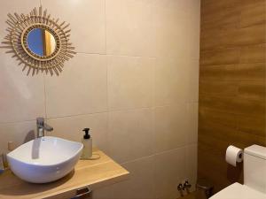 a bathroom with a white sink and a mirror at Casa Cálida entorno natural con vista al Estrecho in Leñadura +28 photos