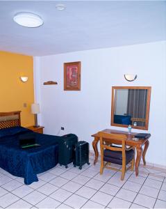 a bedroom with a bed and a table with a desk at Hotel Las Fuentes in Los Mochis +24 photos