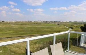 a view of a field from a balcony with two chairs at Covington Close in Calgary +35 photos