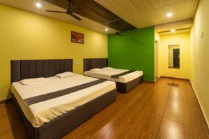 duas camas num quarto com paredes verdes e amarelas em Dandeli Lake leaf - Dandeli Resort em Dandeli