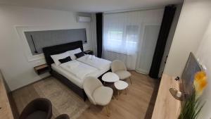 1 Schlafzimmer mit einem Bett sowie 2 Tischen und Stühlen in der Unterkunft Studio apartman OAZA in Vukovar