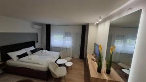 ein Schlafzimmer mit einem Bett, einem Tisch und Stühlen in der Unterkunft Studio apartman OAZA in Vukovar + 7 Fotos