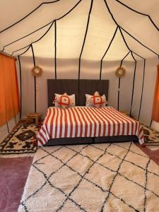 ein Schlafzimmer mit einem Bett in einem Zelt in der Unterkunft Arawan Luxury Desert Camp at Erg Lihoudi in Mhamid