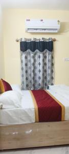 Un dormitorio con una cama con sábanas blancas y una ventana. en AKR Homestay, en Tiruvannāmalai