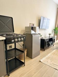 a kitchen with a stove and a refrigerator at Cozystays by Vee Near JKIA in Nairobi