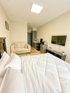 a bedroom with a large white bed and a couch at Cozystays by Vee Near JKIA in Nairobi +27 photos