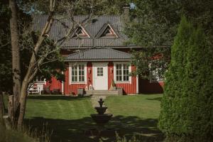 ein rotes Haus mit einem Brunnen davor in der Unterkunft HALI - Hideaway in Raseborg
