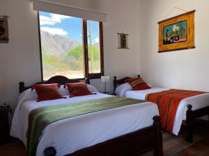 due letti in una stanza con finestra di El Descanso Cafayate a Cafayate