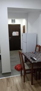 a dining room with a table and a refrigerator at Apartman Neron in Soko Banja