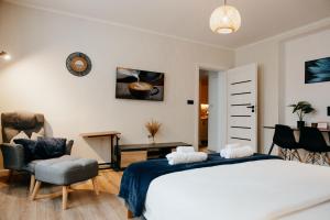 a bedroom with a large bed and a chair at Lusia Apartment in Jarosław +18 photos