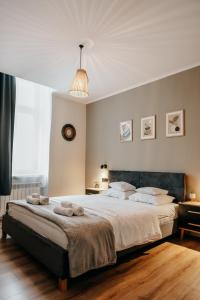 a bedroom with a large bed with towels on it at Lusia Apartment in Jarosław