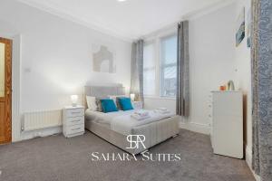 ein Schlafzimmer mit einem großen Bett und blauen Kissen in der Unterkunft Stylish 4BR South Shields Home - Contractors & Family Stay in Westoe