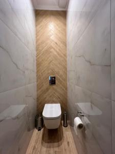 a bathroom with a white toilet and a sink at Kobylianska-Premium 2 Room in Chernivtsi