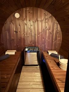 una sauna con una pared de madera con 2 camas en Tiny cocon en pleine nature jacuzzi, sauna privé, en Tinlot