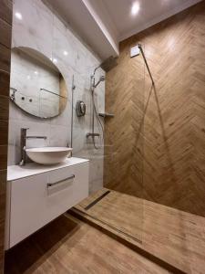 a bathroom with a sink and a glass shower at Kobylianska-Premium 2 Room in Chernivtsi