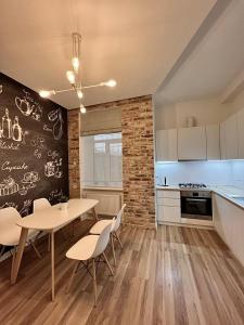 a kitchen and dining room with a table and chairs at Kobylianska-Premium 2 Room in Chernivtsi