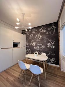 a dining room with a table and chairs and a chalkboard at Kobylianska-Premium 2 Room in Chernivtsi +1 photo