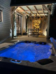 una gran bañera de hidromasaje azul en un patio en Tiny cocon en pleine nature jacuzzi, sauna privé, en Tinlot