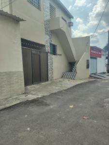 a building with a door and a staircase next to a street at KL Residencial in Manaus