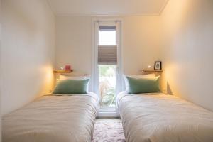 two beds in a room with a window at Buitenlede 7 - Suite M in Dwingeloo