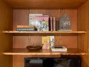 a wooden shelf with books and a bowl on it at Retro Alpine Studio - Terrace with Mountain View in Leukerbad