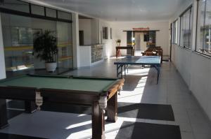 a hallway with two pool tables in a building at Joalpa Hotel Cabo Frio in Cabo Frio