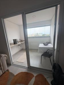 a room with a sliding glass door with a table at Red Building Apartment in Bauru