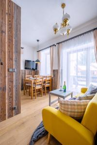 ein Wohnzimmer mit einem gelben Sofa und einem Tisch in der Unterkunft Chata Vermont in Bedřichov