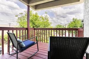 a porch with two chairs on a wooden deck at Nole Worries! in Tallahassee