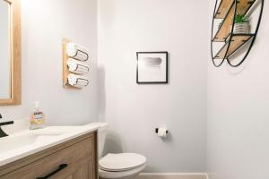 a white bathroom with a toilet and a sink at Nole Worries! in Tallahassee +25 photos