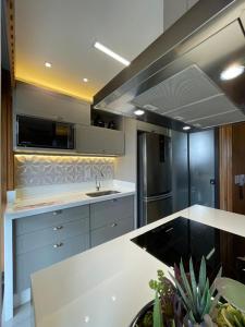 una cucina con lavello e frigorifero di Charmant Vertigo a Campo Grande Altre 9 foto