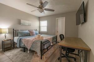 a bedroom with a bed with a fan and a table at Nole Worries! in Tallahassee