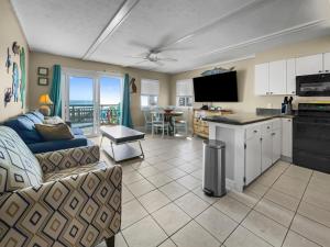 ein Wohnzimmer mit Sofa und eine Küche in der Unterkunft Leeward II 3 l Beachfront Condo l Large first level deck with steps down to sand in Watersound Beach