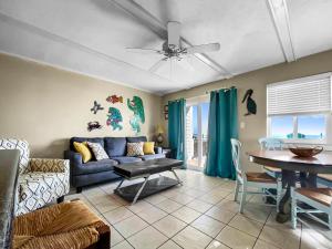 ein Wohnzimmer mit einem blauen Sofa und einem Tisch in der Unterkunft Leeward II 3 l Beachfront Condo l Large first level deck with steps down to sand in Watersound Beach