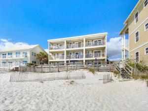 ein großes Gebäude am Strand neben dem Sand in der Unterkunft Leeward II 3 l Beachfront Condo l Large first level deck with steps down to sand in Watersound Beach