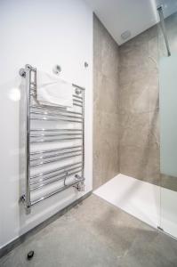 Un baño con ducha y toallero. en Le raffiné, en Mâcon