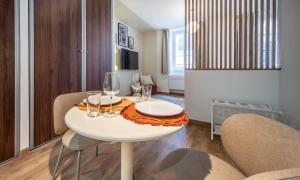 Un comedor con una mesa y sillas blancas. en Le raffiné, en Mâcon