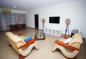 un soggiorno con 2 sedie e un tavolo in vetro di Ocean Heights - One Bedroom a Accra