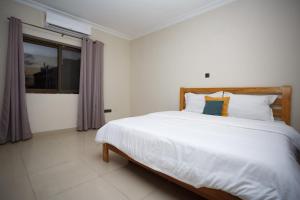 una camera da letto con un grande letto bianco e una finestra di Ocean Heights - One Bedroom a Accra