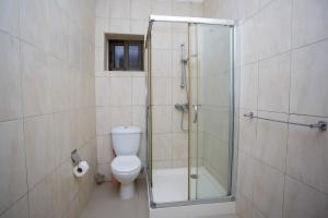 un bagno con wc e doccia in vetro di Ocean Heights - One Bedroom a Accra Altre 8 foto