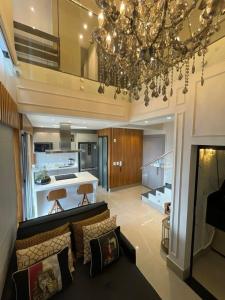 un soggiorno con un divano e un lampadario di Charmant Vertigo a Campo Grande