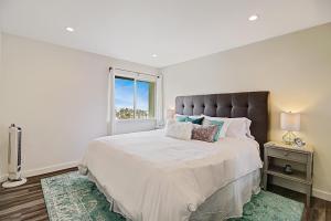 a white bedroom with a large bed and a window at Leadbetter Beach Retreat in Santa Barbara +32 photos