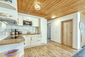 Sundkoje في ألتيفار: مطبخ بدولاب بيضاء وسقف خشبي +17 صورة